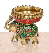 Brass elephant idol with gold urn bowl, red-and-green decorated body, front view