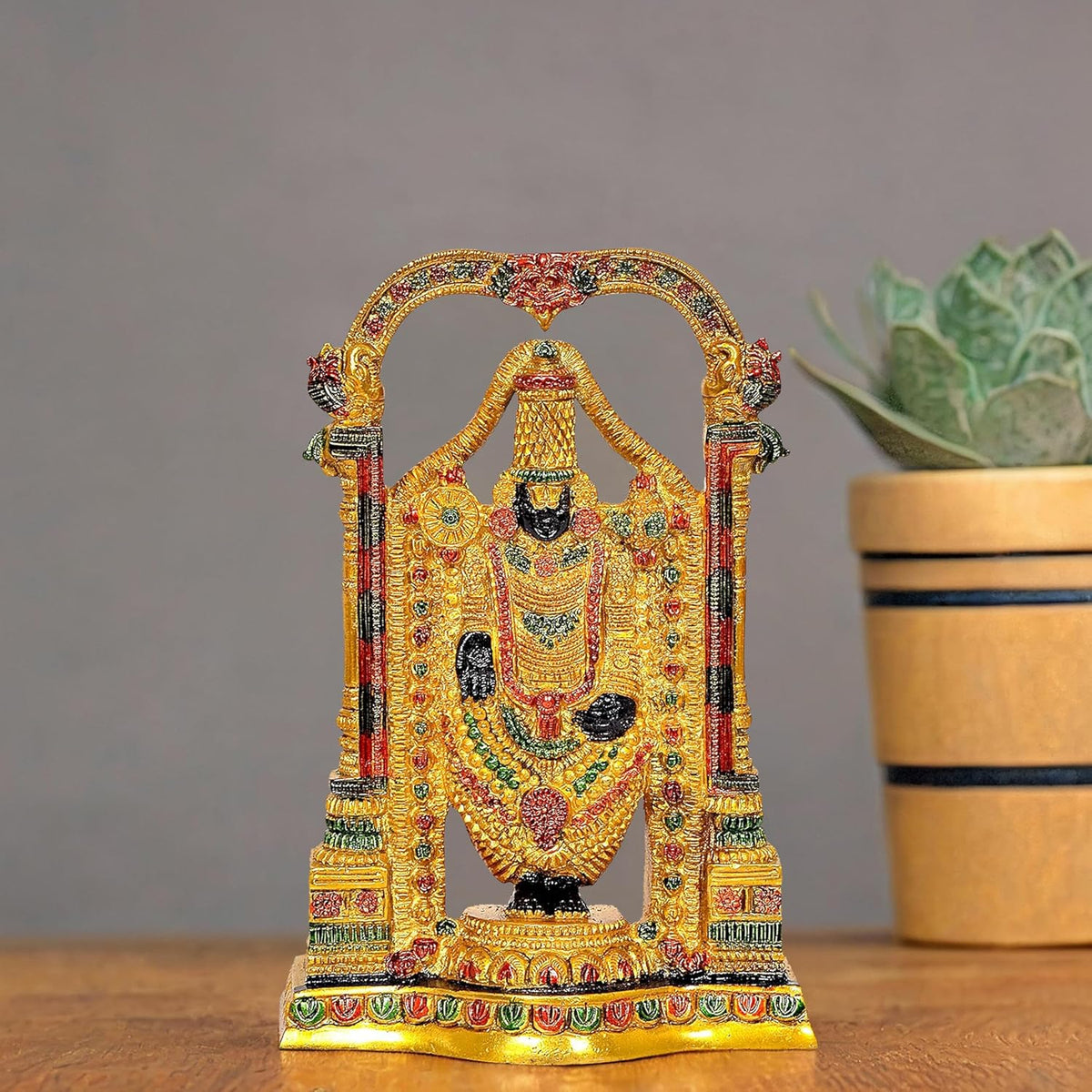 Brass Venkateshwara idol with colorful detailing, arch frame, small seated figure