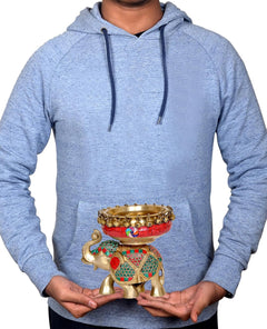 Brass elephant idol with red urli bowl, held in hands for home decor display