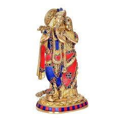 Brass Radha Krishna idol showing embracing figures, detailed gold and jeweled trim