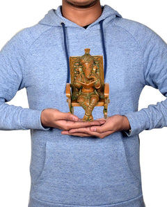 Brass Ganesha statue held by person, reading book on chair, 6.5 in tall