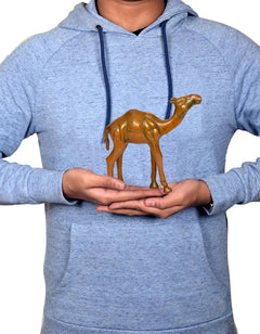 Brass camel figurine held in hands, small decorative sculpture for desk or home