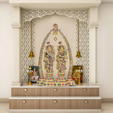 Brass Radha-Krishna statue beneath decorative arch with hanging bells and base