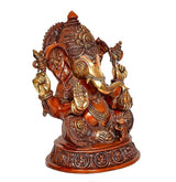 Brass Ganesha statue three-quarter view, trunk to side, gold accents on arms