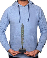 Person holding the vintage bronze phurpa ritual dagger on a dark display base