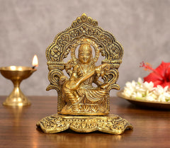 Saraswati Maa seated metal idol, gold tone, ornate arched backrest, 5-inch height