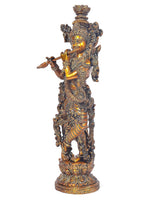 Brass Krishna idol in profile holding flute with detailed crown on ornate pedestal