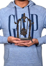 Man holding Ganesha brass swing idol statue on base, chains hanging from frame