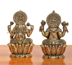 Bronze Lakshmi and Ganesha statues from behind, with symbol medallions on crowns