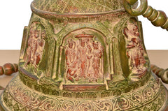 Close-up of Ram Darbar artwork on brass bell base, engraved patterns and accents