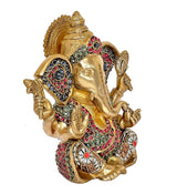Golden brass Ganesha idol statue, close-up profile with jeweled crown and ornaments