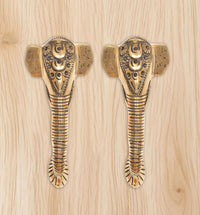 Ganesha face brass door handle pair with striped shank and etched patterns.