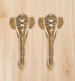 Ganesha face brass door handle pair with striped shank and etched patterns.