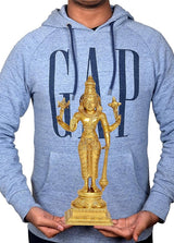 Brass Vishnu statue held by hands, four-armed standing figure on carved pedestal