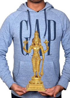Brass Vishnu statue held by hands, four-armed standing figure on carved pedestal