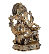 Brass Ganesha statue idol, three-quarter view with raised hand gestures and decorative headdress