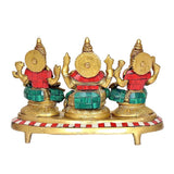 Brass Lakshmi Ganesh Saraswati statue rear view: three gold-backed figures in red and teal