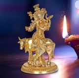 Brass khaniya statue: cow playing flute with ornate figure, front view