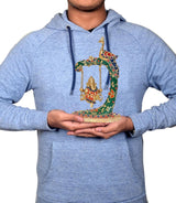 Brass Ganesha jhula statue held up in hands; peacock swing with multicolor details
