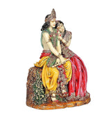Resin Radha-Krishna idol from angle, red and green clothing with golden-yellow cloth