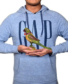Two iron parrot statues held in hands, green, gold, and red accents on gold bases