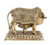 Brass cow showpiece with calf, front view, floral relief design on back panel