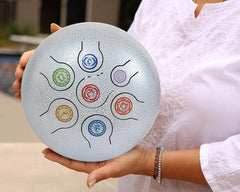 Silver steel happy drum with colorful spiral note pattern, held in hands
