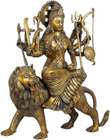 Brass Goddess Durga statue seated on lion, holding trident, sword, and round shield