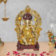 Brass Ganpati Bappa idol with ornate gold-toned arch, dark crown, on red base