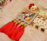 Toran detail: red tassel charms, gold bells, pearl beads, and framed deity art