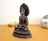 Resin Buddha sculpture side view, seated in dark finish with blue base detail