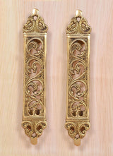Pair of golden brass door pull handles with vertical filigree flower motifs