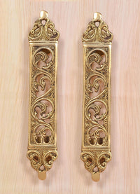 Pair of golden brass door pull handles with vertical filigree flower motifs