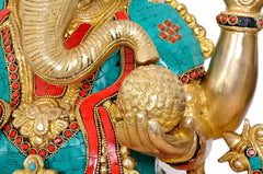 Close-up of Ganesha’s trunk and gold textured ornament with teal and red painted panels