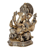 Brass Ganesha statue idol, side angle showing trunk curve, four arms and seated base