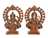 Brass Lakshmi and Ganesha idols with gold detailing, seated inside circular arch frames