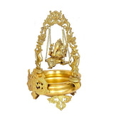 Brass Ganesha swing urli side view with ornate tray base and hanging swing frame