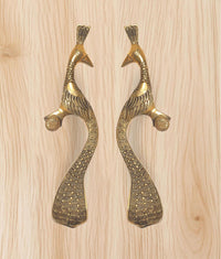 Peacock motif brass door handles with curved bodies and round thumb grips