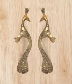 Peacock motif brass door handles with curved bodies and round thumb grips