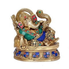 Brass Ganesha figurine eating ladoo, seated on ornate asan with colorful jewel details