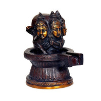 Brass Shiva linga statue with three faces and engraved base, angled side view