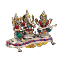 Ganesh, Lakshmi and Saraswati brass idols with colored garments on pedestal base