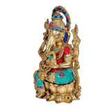 Messing-Ganesha-Idol von der Seite, mit blau eingefassten Ohren und türkis-rotem Gewand