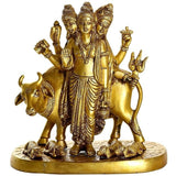Brass Trimurti Hindu idol figurine, three-headed deities with arms raised, on cow base