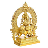 Golden brass Durga idol riding a lion, detailed headdress and swirling halo frame