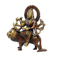 Brass Durga goddess statue on lion, gold-toned face, multiple arms with ornaments