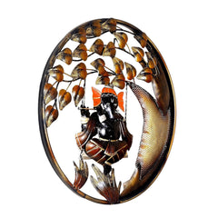 Close-up of Ganesha on swing playing flute, orange headdress and gold leaf vines