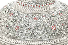 Close-up of silver carved chattar with red enamel floral medallions and embossed scrollwork