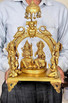 Brass Ram Darbar murti held in hand, showing chhatra top and singhasan base