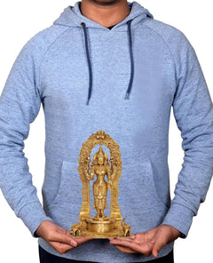 Brass Lakshmi-Laxmi standing murti held in hands on light blue hoodie backdrop